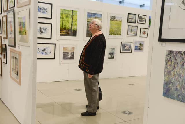 Visitors take in the various paintings on display at the great Sheffield Art show held at the Millennium Galleries