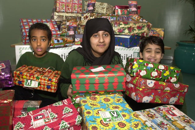 Seen with some of the boxes for Operation Christmas Child in 2000 were LtoR are,  Ahmed Ali, Fauzia Hussain, and Wael Sheibi.