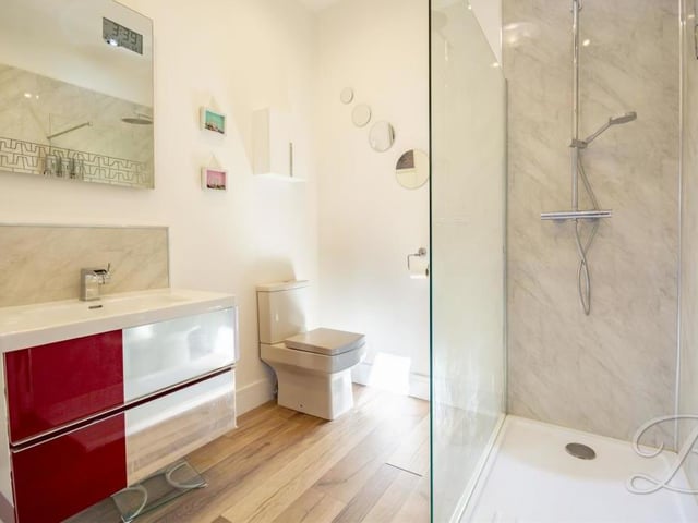 The third en suite also features a walk-in, enclosed shower. Like the other two, the room is smooth and sleek.