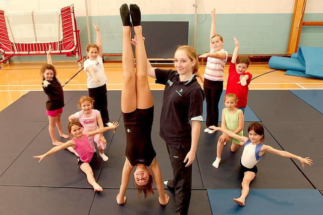 Fitness coach Nicola Richmond holds 12-year-old Sophie Robinson in place with other schoolchildren during the half term gymnastics session at Wellfield Comprehensive School six years ago.