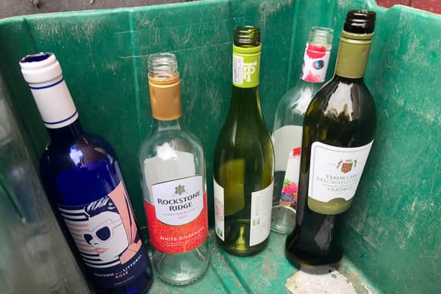 Empty wine bottles in a recycle bin.
