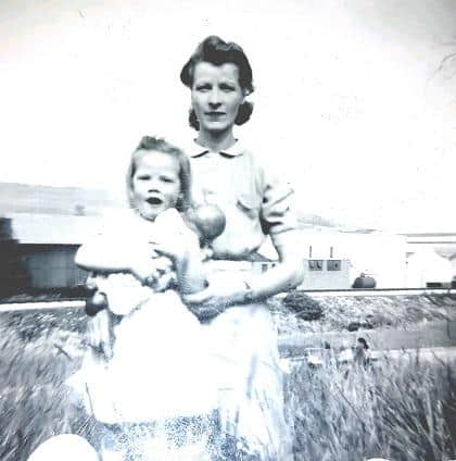 Alice, in her 20s, holding one of her children.