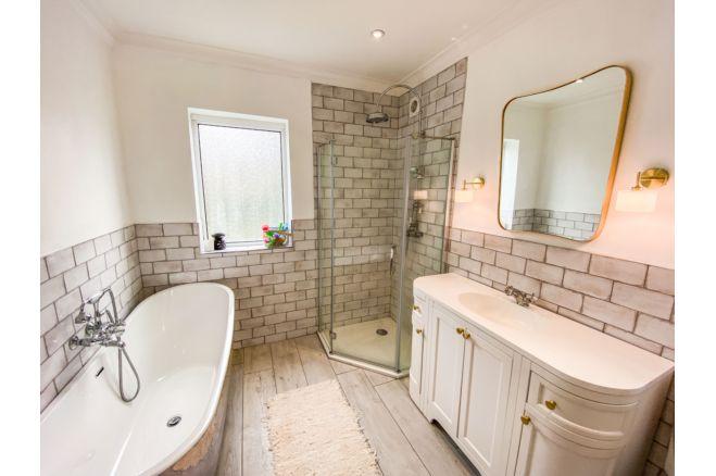 This lovely family bathroom offers a bath tub, vanity unit, separate shower cubicle and toilet.