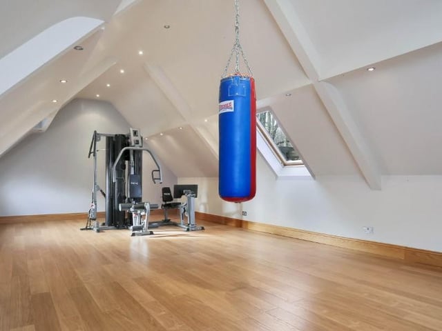 The large, detached garage has room for five cars, plus its own alarm system, storage space and a bespoke shed. On its first floor is this large and versatile room that is currently being used as a gym.