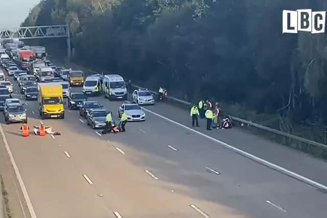 Image courtesy of LBC showing police officers removing Insulate Britain activists from the M25 between junctions 9 and10 where the climate protesters carried out a further action after demonstrations which took place last week across junctions in Kent, Essex, Hertfordshire and Surrey. Picture date: Tuesday September 21, 2021.