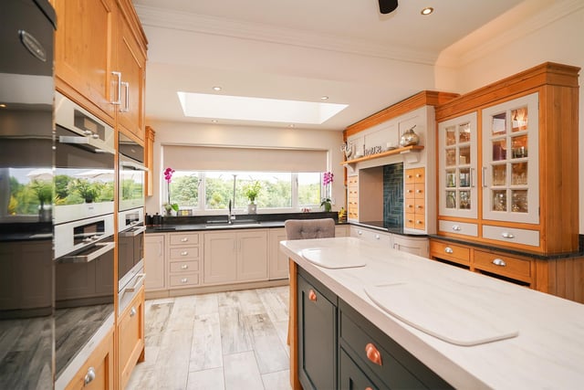 The kitchen is expertly finished with bespoke cabinets and the worktops made of corian and granite.