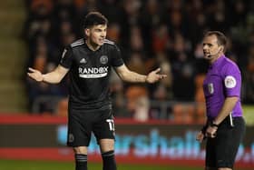 Sheffield United's John Egan questions the offside goal decision with referee Geoff Eltringham during the match at Blackpool on Wednedday night. Andrew Yates / Sportimage