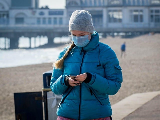 A woman wears a mask in Southsea on March 27.