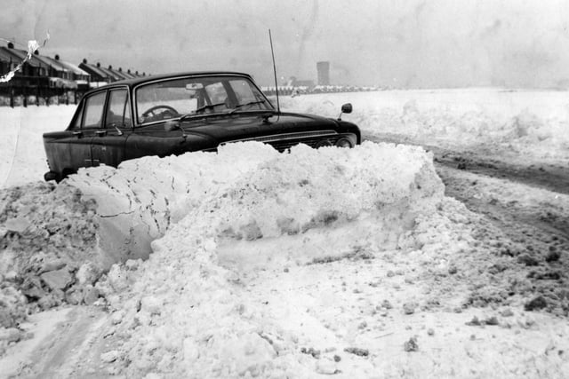 A car is stuck in the snow on the Coast Road in South Tyneside this scene which looks like it dates back 50 years or more.