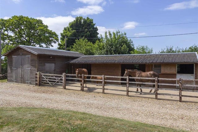 The property has its own stable yard and equestrian facilities, with the yard enclosed within post and rail fencing with two open shelters and a traditional stable.