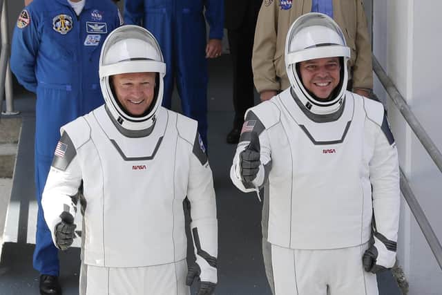 NASA astronauts Douglas Hurley, left, and Robert Behnken walking out of the Neil A. Armstrong Operations and Checkout Building on their way to Pad 39-A, at the Kennedy Space Center in Cape Canaveral on May, 30, 2020 (AP Photo/John Raoux, File)