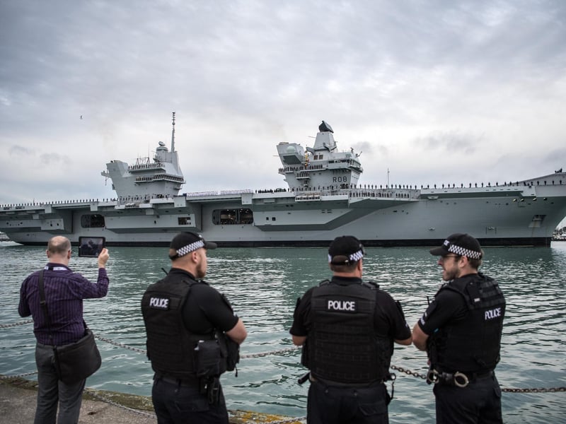 Armed police chat as HMS Queen Elizabeth sails into her home port of Portsmouth Naval Base on August 16, 2017. Picture: Carl Court/Getty Images