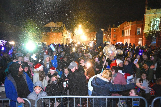 Artificial snow decends on the crowds enjoying the festive fun.