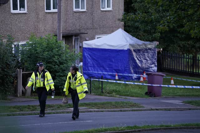Police officers walk past a police tent at the scene in Chandos Crescent in Killamarsh, near Sheffield, where four people were found dead at a house on Sunday. Derbyshire Police said a man is in police custody and they are not looking for anyone else in connection with the deaths (pic: Danny Lawson/PA Images)