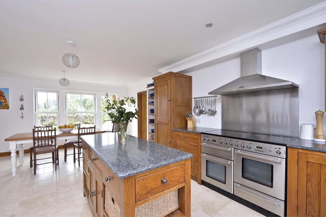 The spacious open-plan kitchen and dining area boasts modern fixtures and fittings
