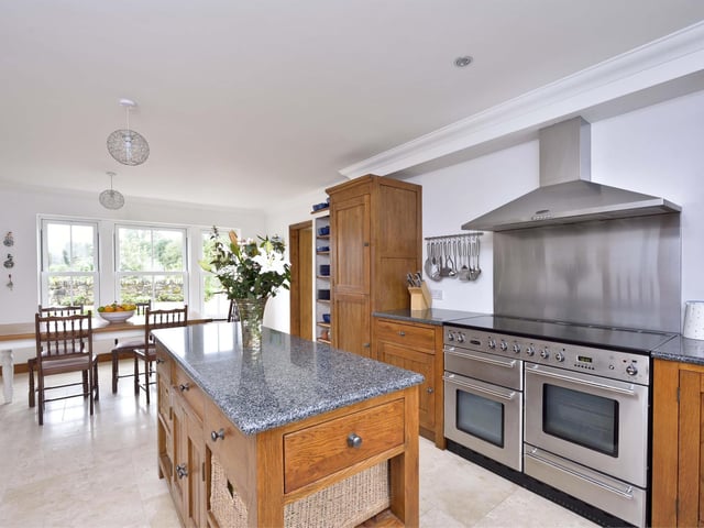 The spacious open-plan kitchen and dining area boasts modern fixtures and fittings