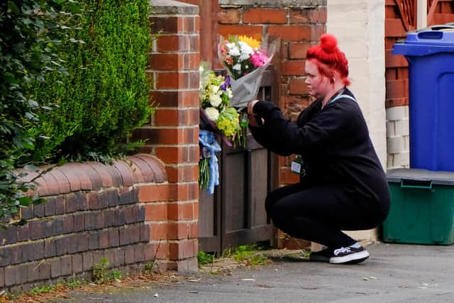 A woman places flowers at the home on Welfare Road in Doncaster where a 12 week old baby was killed by a dog. September 16, 2020.