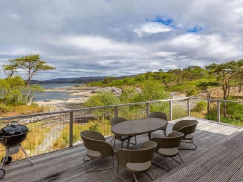 The outdoor decked area features a barbecue.