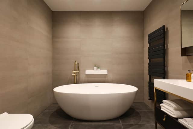 This bathroom features a free standing bath and tiled finish.