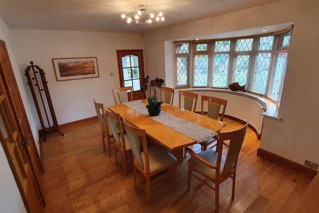 The dining room features UPVC double glazed ledged bay windows to the front, curved radiators, oak plank flooring and double front doors to wall