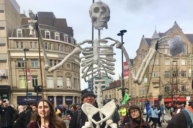 Extinction Rebellion protesters hold up a skeleton at the demonstration outside Sheffield Town Hall.