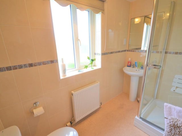 Ensuite shower room - Nicely positioned next door to bedroom one and incorporates a large corner shower cubicle with chrome fittings, wash basin with pedestal, low level flush wc, central heating radiator, UPVC double glazed obscure window, shaving socket, loft access to the ceiling and complimented with attractive ceramic tiles.