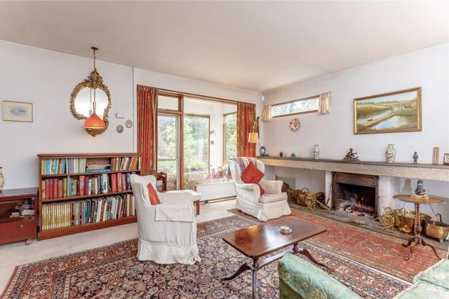 The living room benefits from large windows and an open fire