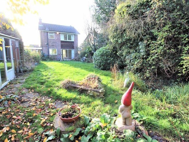 Our final look at the Ollerton house shows the back garden in all its glory. It is fully enclosed and mainly lawned, with an abundance of mature shrubs. But there is also a patio area for seating and a summerhouse (left) with electricity.