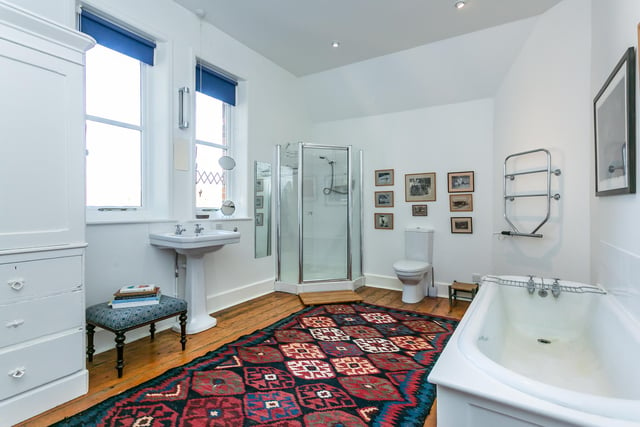 There bathrooms are featured around the property, including this large family bathroom complete with a bath, walk-in shower, WC, hand wash basin and storage cupboards.