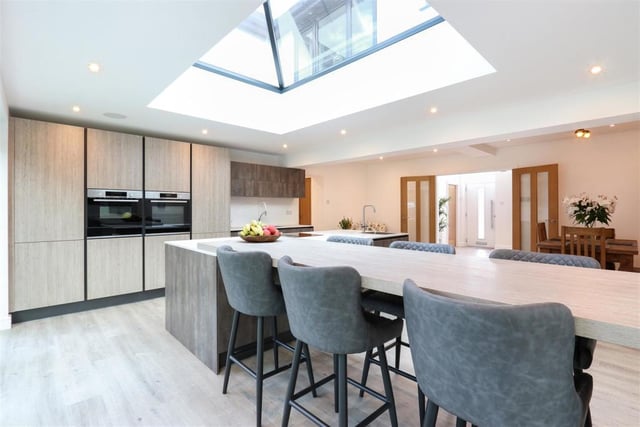 Sit down to home-cooked meals in this stunning open-plan Karl and Benz dining kitchen which has double integrated ovens and induction hob.