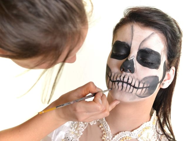 This spooky look can be created with black eyeliner, eyeshadow and foundation. Make your foundation pale by adding talc to it (or use white face paint, if you have it) then create the skull with heavy black eye shadow around the eyes and the tip of your nose. Add the intricate lines of the mouth using an eyeliner pencil.