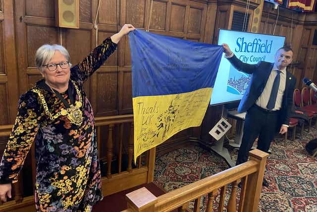 Sheffield Lord Mayor Sioned-Mair Richards and Oleksandr Symchyshyn, mayor of Khmelnytskyi, holding a Ukrainian flag signed by fighters on the front line.