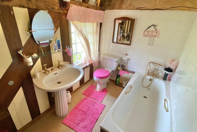 Even this bathroom has exposed beams to the ceiling. It is fitted with a suite comprising a bath with shower attachment, wash hand basin and low-flush WC.