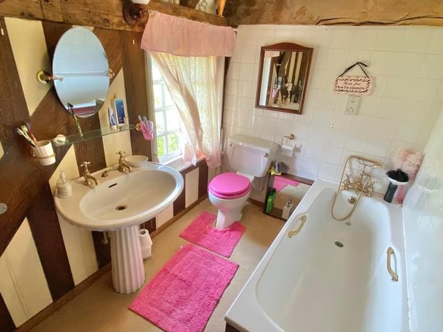 Even this bathroom has exposed beams to the ceiling. It is fitted with a suite comprising a bath with shower attachment, wash hand basin and low-flush WC.