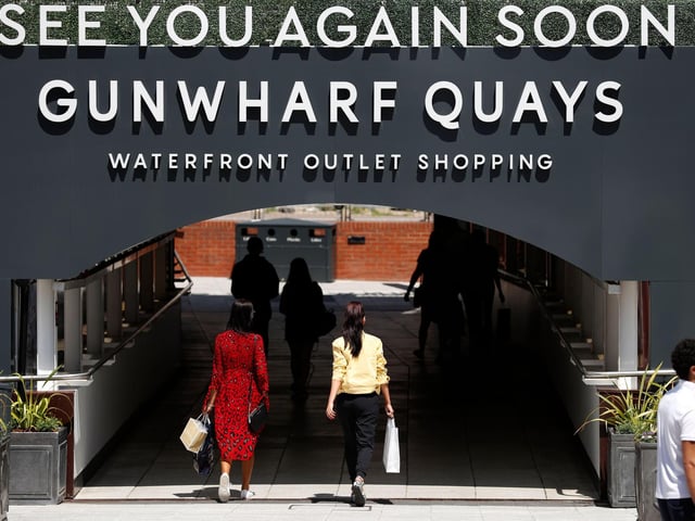 Shoppers carry bags as they leave after visiting recently re-opened shops at Gunwharf Keys shopping centre in Portsmouth as some non-essential retailers begin to reopen.