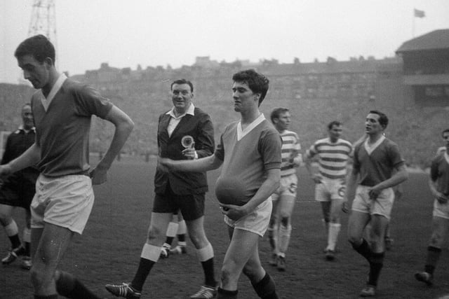 The referee laughs when Rangers' Jim Baxter 'hides' the ball up his jumper after the Old Firm Rangers v Celtic Scottish Cup Final at Hampden in 1963.