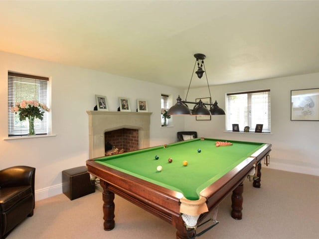 Currently used as a games room, with ample space to house a full-length snooker table, this space could be converted into an additional living room and boasts a central fireplace at its heart.