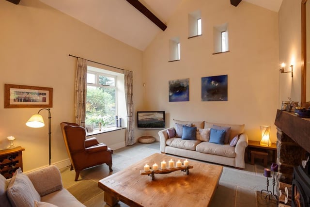 The living area has a front-facing timber double glazed window, vaulted ceiling, exposed beams and stone flagged flooring with underfloor heating. The focal point of the room is the rustic fireplace with a log burner, timber mantel and a stone hearth.