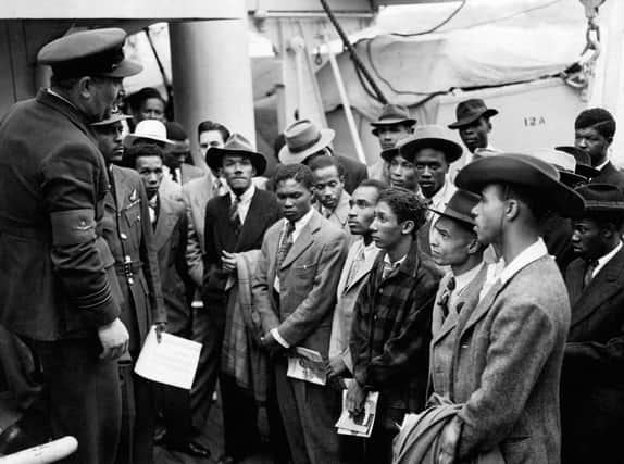 People from the Caribbean who answered Britain's call to help fill post-war labour shortages being welcomed by RAF officials from the Colonial Office after the ex-troopship HMT Empire Windrush landed them at Tilbury. PA Wire