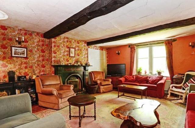 The sitting room includes a feature fireplace with a cast iron inset and tiled hearth and back, which is subject to a preservation order.