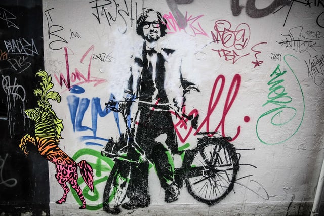 A 'Banksy style' stencil of Pulp frontman Jarvis Cocker riding a bike near the Workstation, Sheffield in June 2014. The artist Stewy, based in Bristol, had permission to create the works of art from property owners in West and South Yorkshire in the build-up to the Tour de France Grand Depart