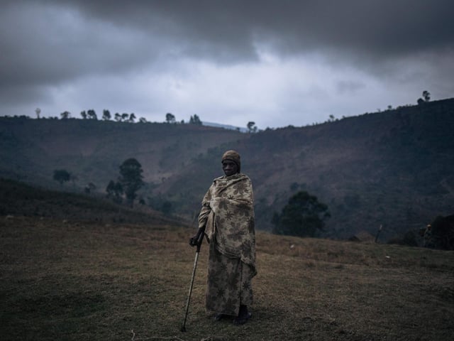 Josephine Kabike, a displaced woman of unknown age, poses for a photograph. She was severely injured by gunfire during a militia attack on the internally displaced persons site.