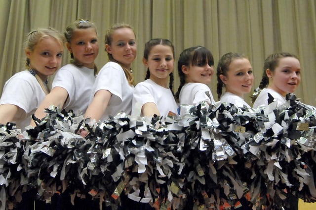 A cheerleading team takes a moment for a photo.