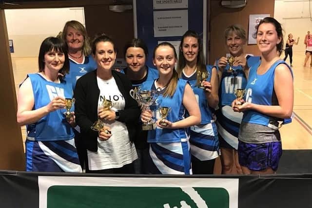 Nikki, second from right, celebrates winning a trophy with her netball team