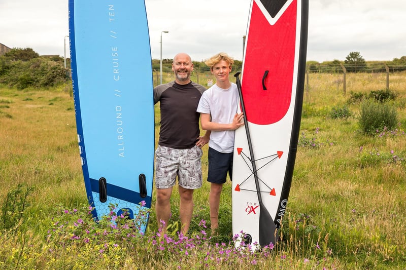 Graham O'Neil (49) and son Owen O'Neil (15) trek across the moorland by Fort Cumberland to enjoy an afternoon at the beach with their Stand Up Paddle Boards. Picture: Mike Cooter (150721)