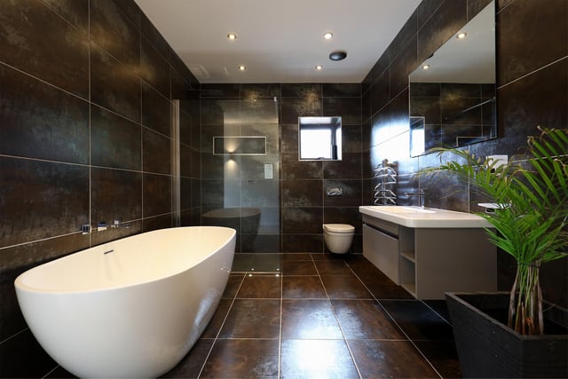 The main bedroom's en-suite bathroom has a free-standing tub and tasteful charcoal grey tiles.
