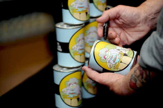 Pete McKee with some of the specially-designed soup tins that the first 500 members of the public received in return for donations to a pop-up food bank on Division Street in Sheffield in June 2018