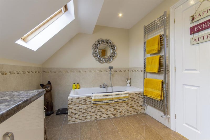 The family bathroom is part tiled and fitted with a white four-piece suite comprising a tiled-in bath with bath/shower mixer tap, corner shower cubicle with mixer shower, wash hand basin with storage below and a low-flush WC.
