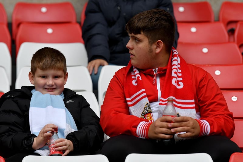 Two Sunderland supporters enjoy a bottle of pop before the game.