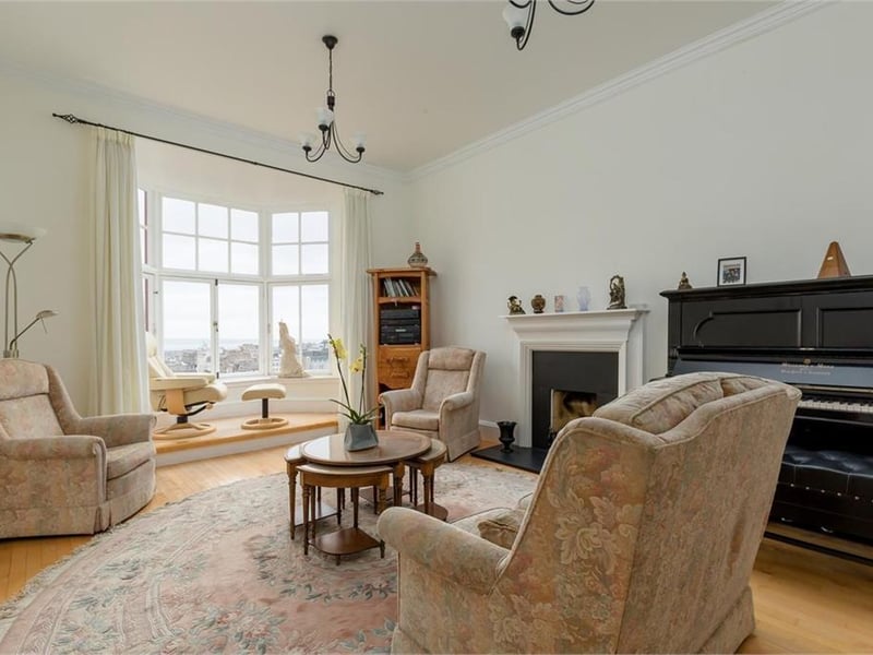 Elegant drawing room with bay window and uninterrupted views over Princes Street and beyond.